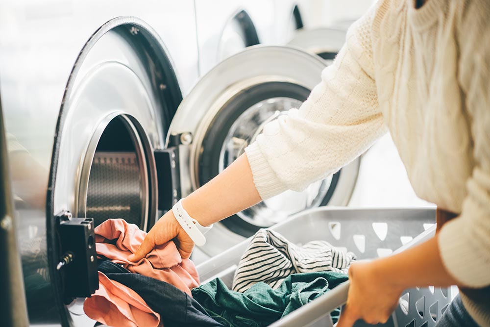 interior of small laundromat in daylight. close up female holdin